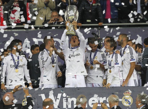 Real Madrid players are covered in confetti as they hold the Champion League trophy at the end of the Champions League final soccer match between Atletico de Madrid and Real Madrid in Lisbon, Portugal, Saturday, May 24, 2014. (AP Photo/Daniel Ochoa de Olza)