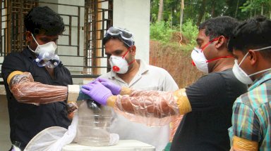 خبراء يحتفظون بخفاش لاستخدامه في بحوثهن عن فيروس نيباه، في كيرالا الهندية في مايو 2018