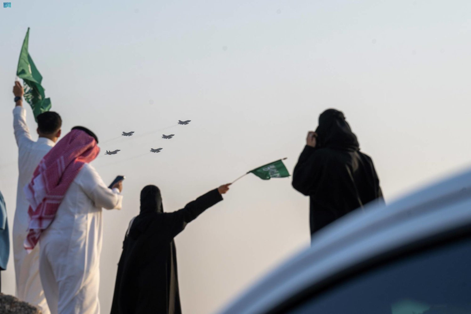 سعوديون يشاهدون عرضا جويا أمس ضمن احتفالات اليوم الوطني (واس)
