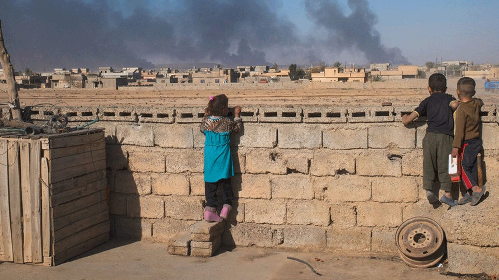 صورة أرشيفية لأطفال عراقيين يراقبون دخان الانفجارات