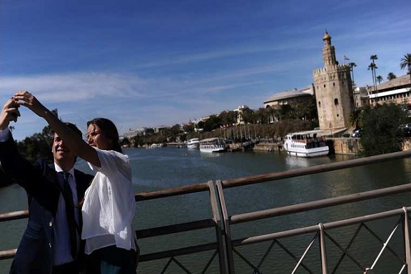 شاب وفتاة يأخذان صورة تذكارية على احد جسور اسبانيا