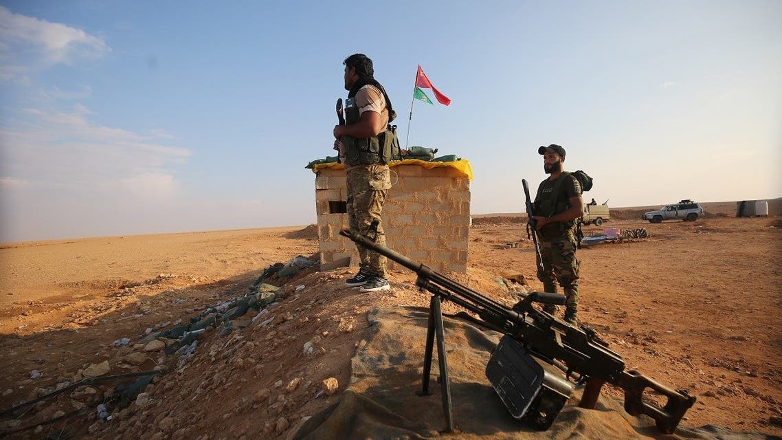 مقاتلون شيعة عراقيون من ميليشيات الحشد الشعبي يؤمنون الحدود في القائم بمحافظة الأنبار مقابل البوكمال بمنطقة دير الزور السورية.