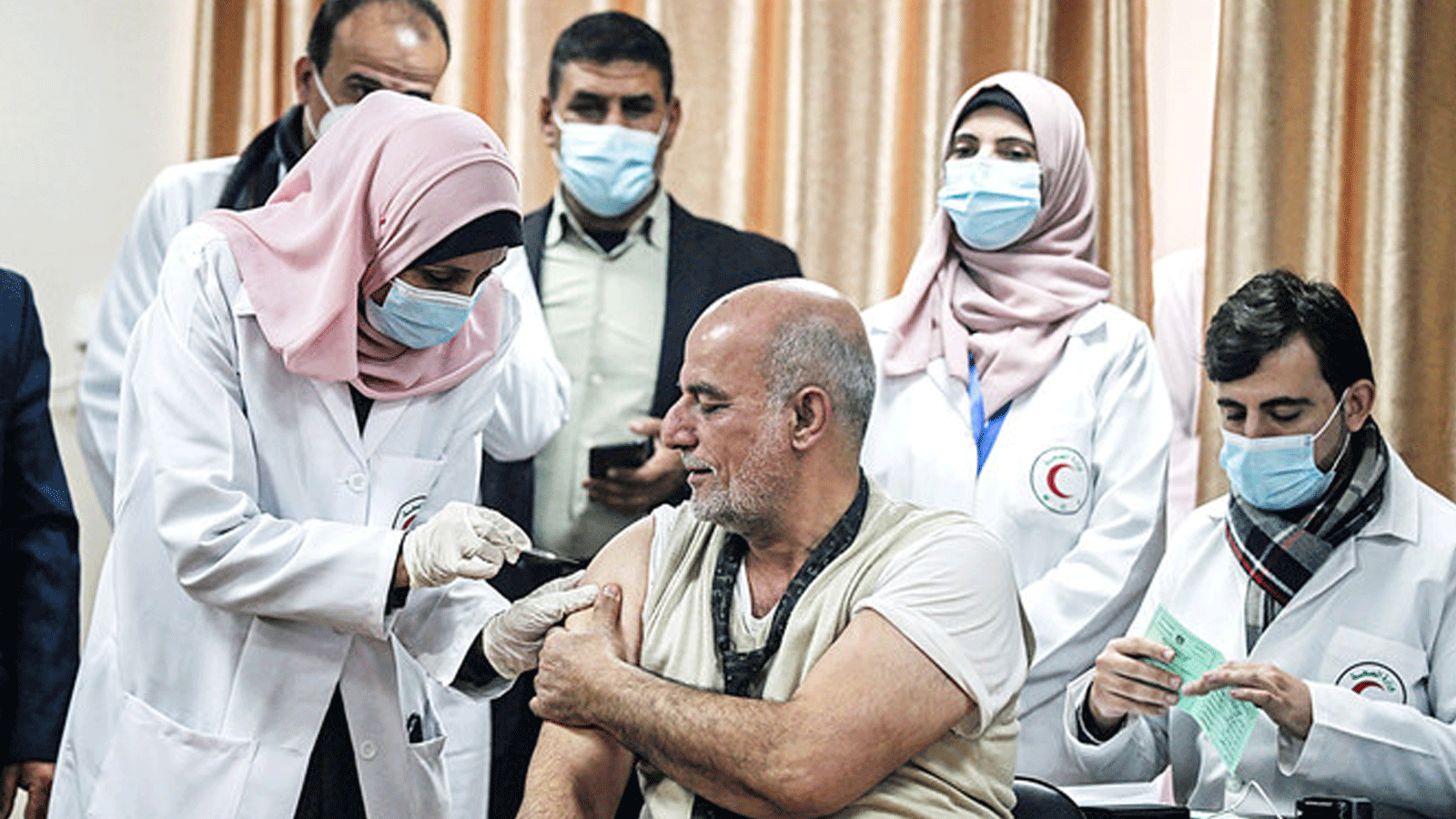 وزير الصحة الفلسطيني الأسبق جواد الطيبي يتلقى جرعة من لقاح فيروس كورونا Sputnik V الروسي في مدينة غزة