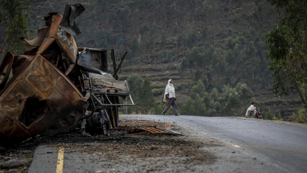 رجل يعبر قرب شاحنة مدمرة على الطريق المؤدي إلى بلدة أبي عدي بمنطقة تيغراي شمال إثيوبيا