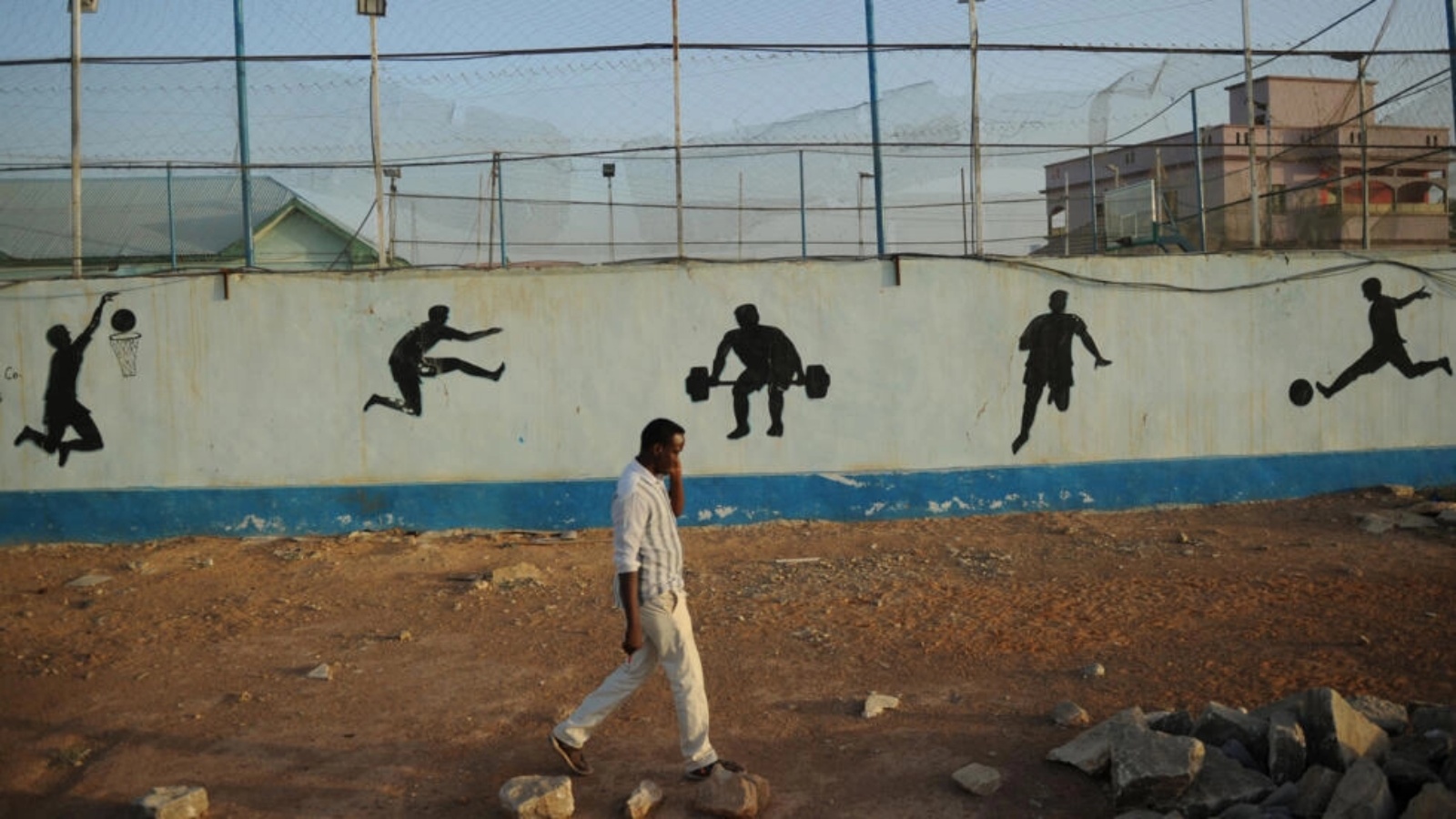 رجل يسير أمام جدار عليه رسوم غرافيتي في 23 يناير 2018 في غاروي في ولاية بونتلاند الانفصالية الشمالية في الصومال