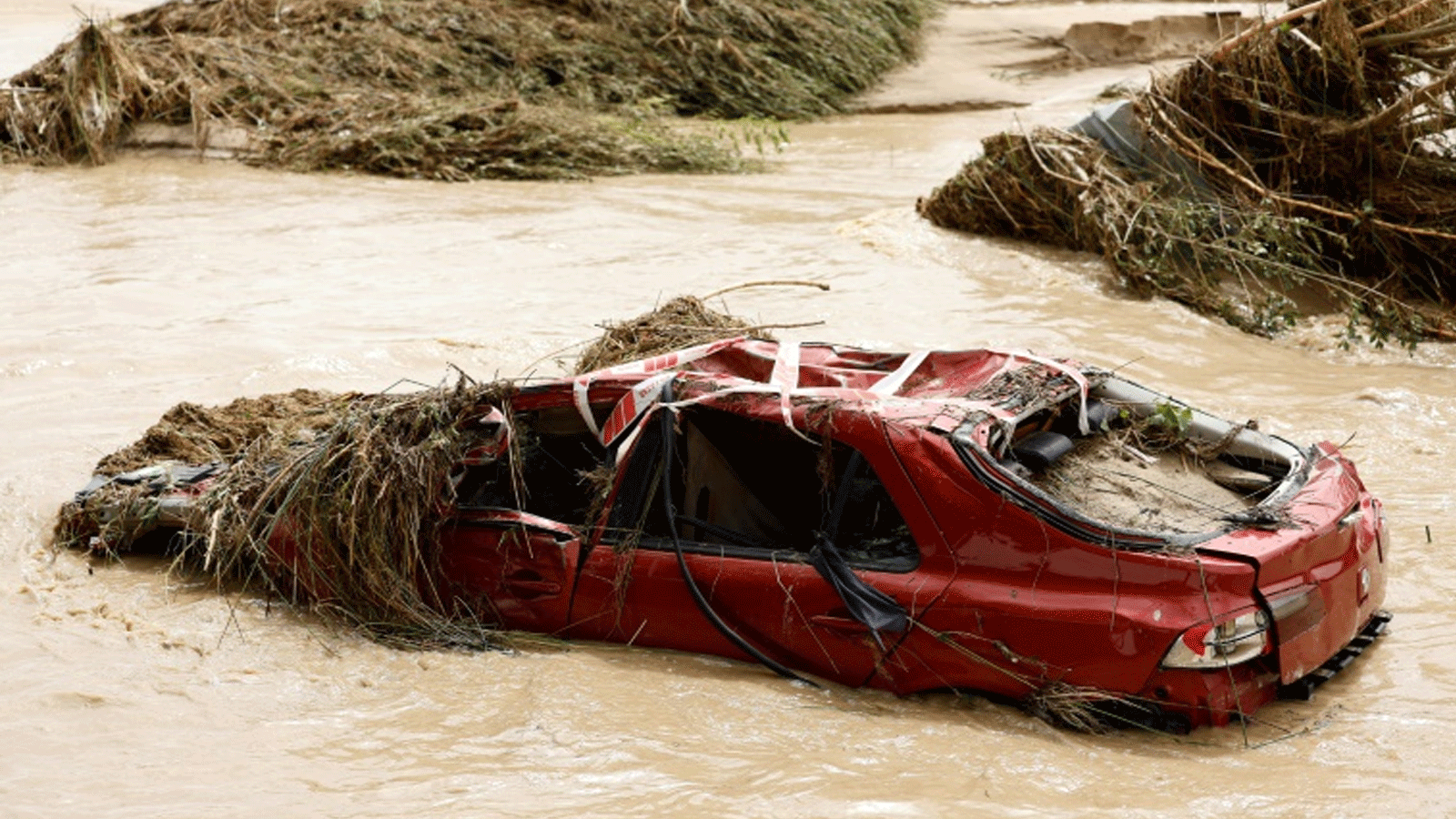 سيارة مدمرة وسط نهر في بلدة ألديا ديل فريسنو في منطقة مدريد، حيث تسببت الأمطار الغزيرة في فيضانات مفاجئة