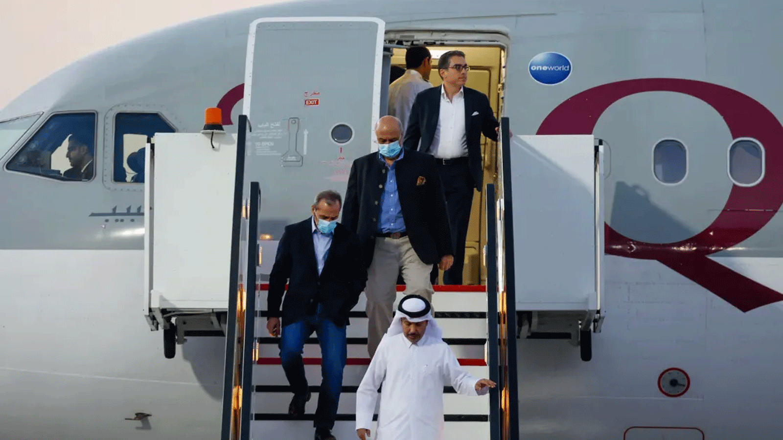 المواطنون الأميركيون من اليسار، عماد شرقي ومراد طهباز وسياماك نمازي، ينزلون من الطائرة القطرية لدى وصولهم إلى مطار الدوحة الدولي