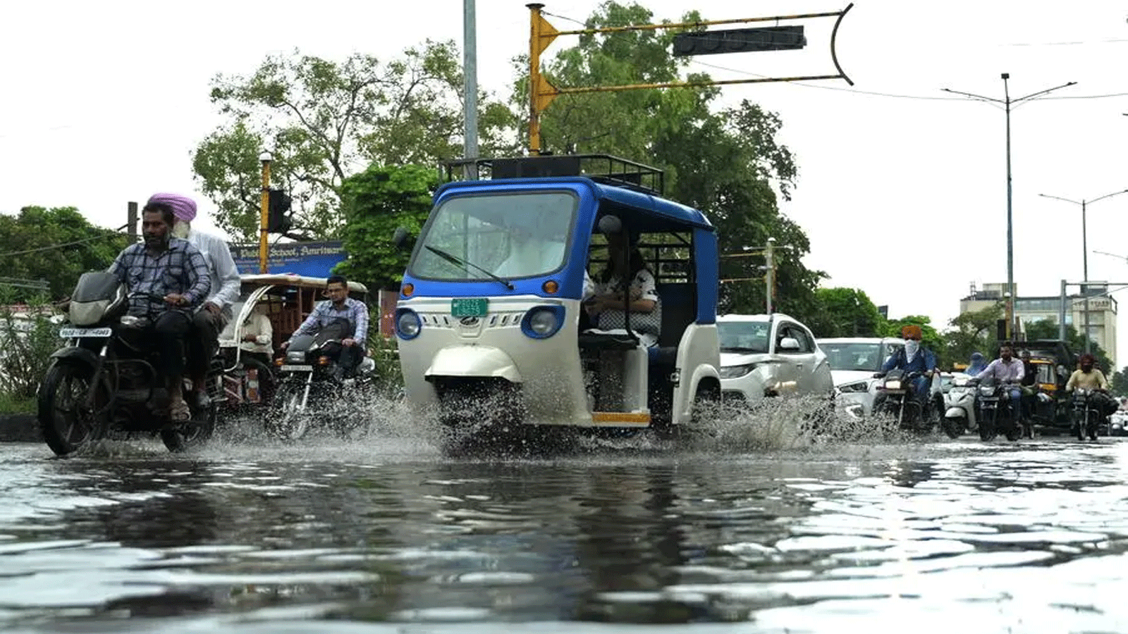 ركاب يشقون طريقهم عبر شارع مغمور بالمياه بعد هطول أمطار غزيرة في أمريتسار في 18 سبتمبر(ايلول) 2023