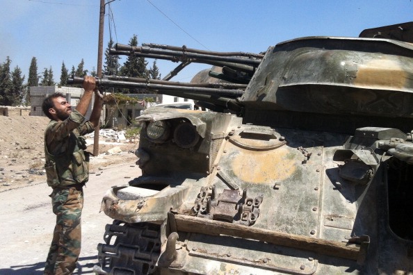 جندي من القوات السورية الموالية للأسد يتفقد آلية عسكرية