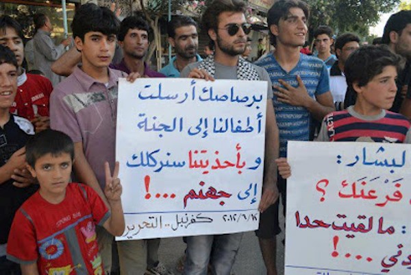متظاهرون ضد الأسد يحملون لافتات ضد الأسد