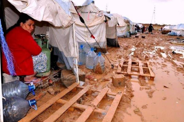 نازحون عراقيون في خيامهم ومياه الأمطار تحيط بهم