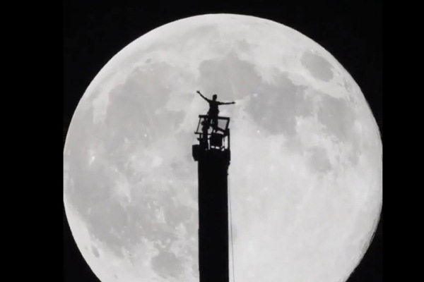 حمدان بن حمدان على قمة برج خليفة وخلفه القمر العملاق