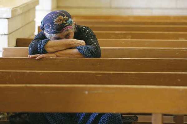 مسيحية مسنة في إحدى كنائس الموصل