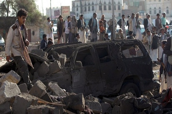 يمنيون يقفون في موقع استهدفته غارة سعودية ضد المليشيات الحوثية بالقرب من مطار صنعاء