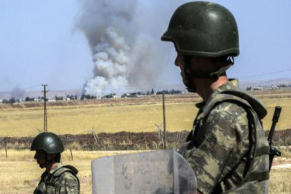  جندي تركي ينظر إلى مدينة كوباني الحدودية وقد تصاعدت فيها أعمدة الدخان- ا ف ب