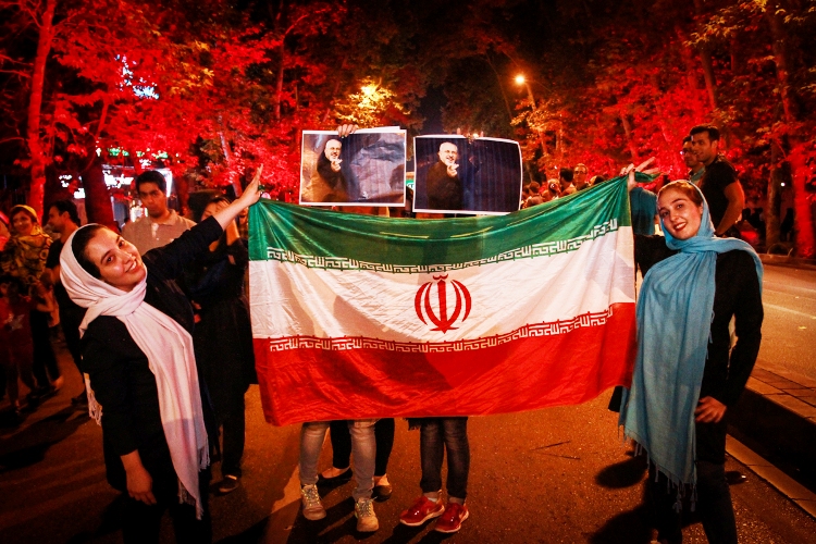 إيرانيون يرفعون علم بلادهم وصورا لوزير الخارجية جواد ظريف احتفالا بتوقيع الاتفاق النووي 