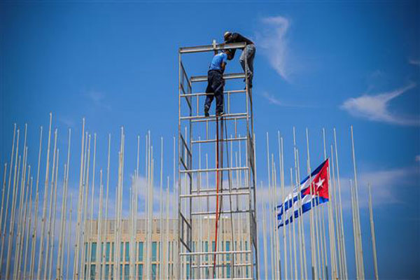 عمال كوبيون يقومون بتحضير مبنى السفارة الأميركية (أ. ف. ب)