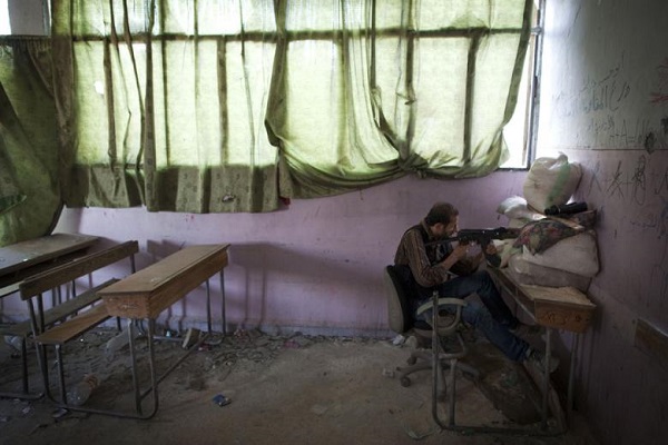 مقاتل يتحصن في احدى المدارس المدمرة في حلب