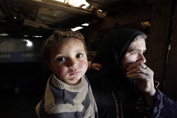 لاجئة سورية تحمل طفلها
