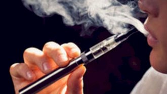 شاب يدخن سيجارة إلكترونية. (توضيحية- من صفحة UK Health Security Agency في تويتر)