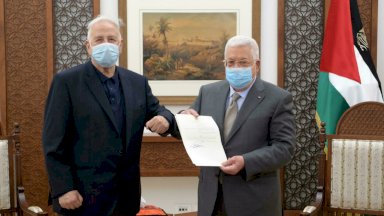 الرئيس الفلسطيني محمود عباس (إلى اليمين) يقدم مرسوم الانتخابات لرئيس اللجنة المركزية للانتخابات حنا ناصر في مدينة رام الله بالضفة الغربية