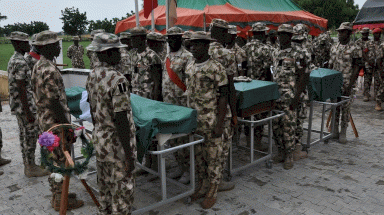 جنود نيجيريون يقفون على أهبة الاستعداد خلال تشييع جنازة رفاقهم الذين قتلوا في الهجوم قرب شواطئ بحيرة تشاد في 26 أيلول/سبتمبر 2020.