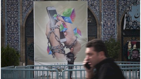 Getty Images رجل إيراني يحمل هاتفه الذكي وهو يقف تحت لافتة مناهضة لوسائل التواصل الاجتماعي في سوق طهران الكبير في 3 ديسمبر/ كانون الأول 2022