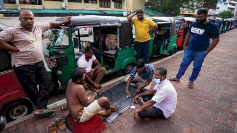 صورة مؤرخة في 18 حزيران/يونيو 2022 لمواطنين سريلانكيين يلعبون بالورق خلال انتظارهم في الدور لتعبئة وقود في كولومبو
