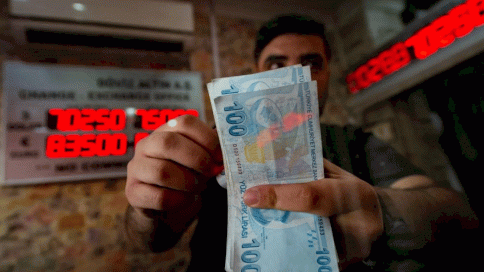 عامل في مكتب صرافة يحصي أوراق الليرة التركية في اسطنبول