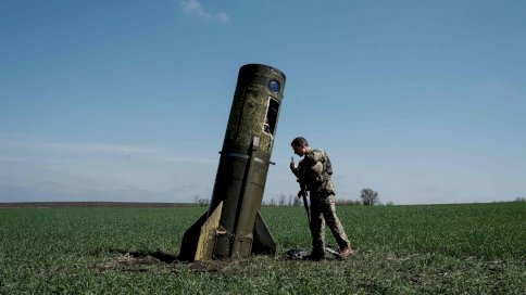 جندي أوكراني ينظر إلى بقايا صاروخ باليستي روسي سقط في حقل في بووداروف، شرق أوكرانيا
