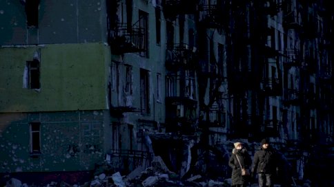 شخصان يمشيان قرب مبنى سكني مدمّر في بلدة سيفيرودونيتسك الخاضعة لسيطرة أوكرانية في منطقة لوغانسك بشرق أوكرانيا في 24 يناير 2023