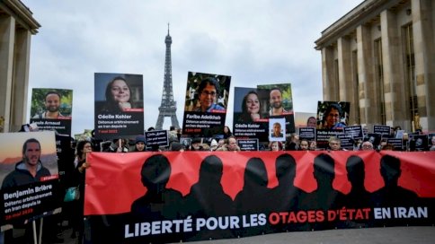 متظاهرون يرفعون صور الفرنسيين المحتجزين في إيران خلال تجمّع في باريس بتاريخ 28 يناير 2023 