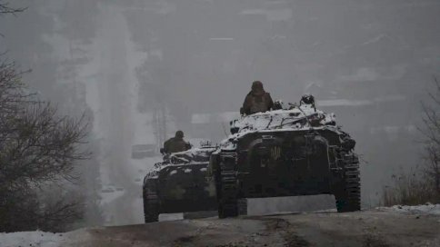 أوكرانيون يقودون مركبات عسكرية على طول طريق جليدي في منطقة دونيتسك